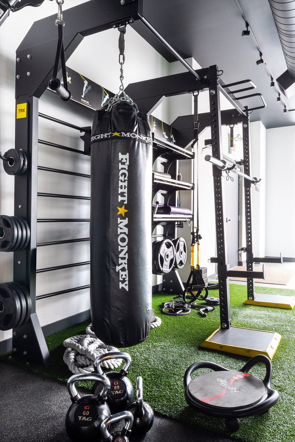 a home gym with a punching bag hanging from the ceiling and weights on the floor