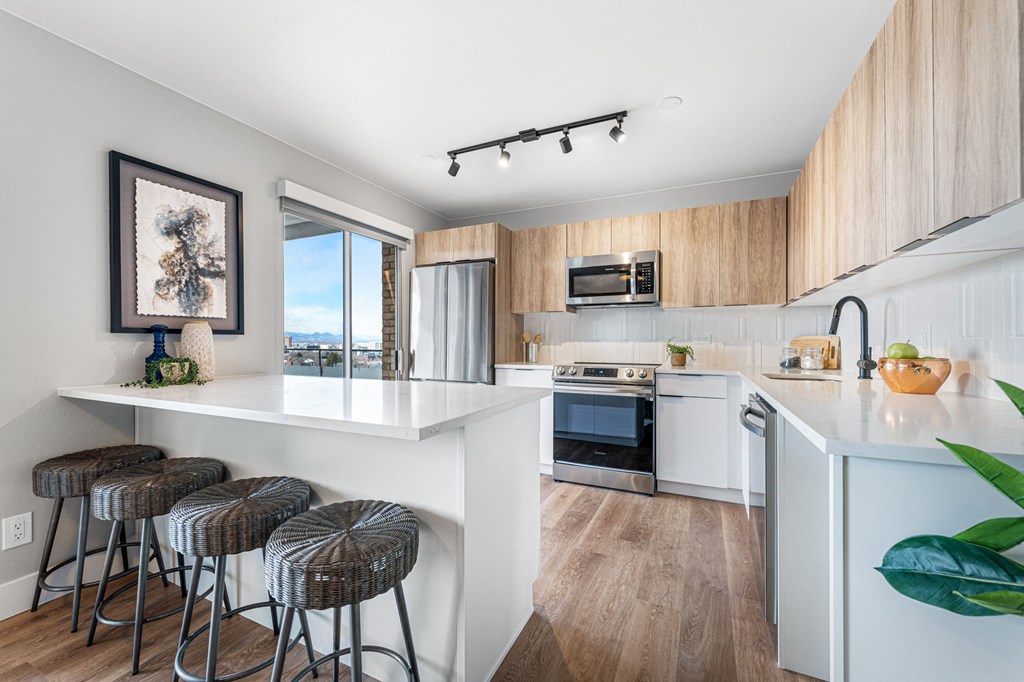 a kitchen with a white counter top and a bar with stools
