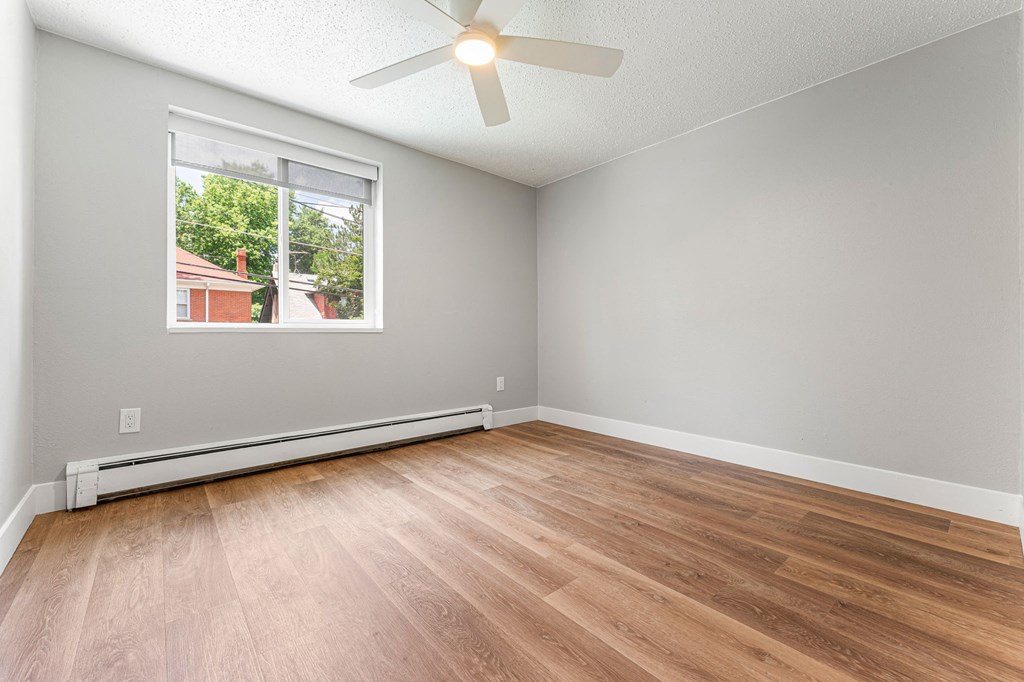 a bedroom with hardwood floors and a ceiling fan