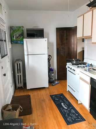 a kitchen with a white refrigerator freezer next to a stove top oven