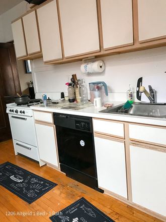 a kitchen with white cabinets and a black dishwasher