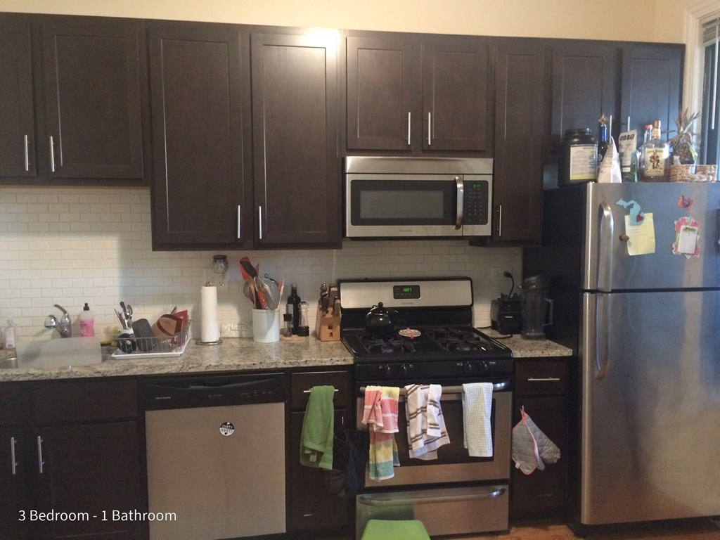 a kitchen with stainless steel appliances and black cabinets