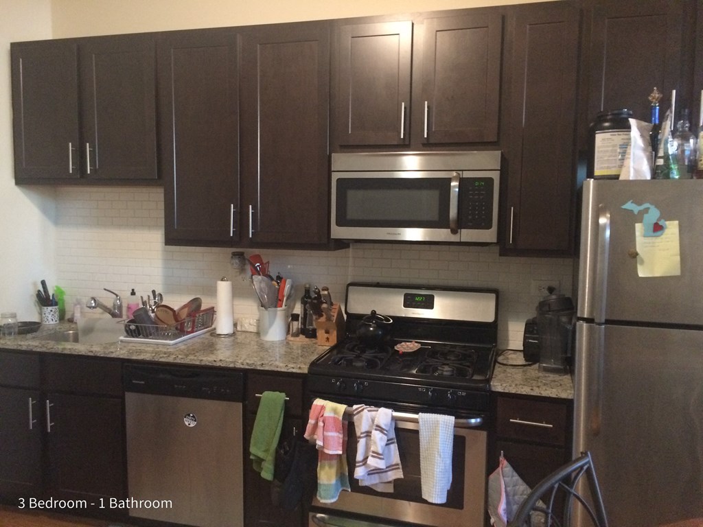 a kitchen with wooden cabinets and stainless steel appliances