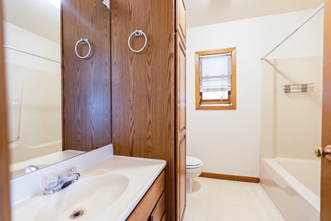 A bathroom with a white sink and a toilet.