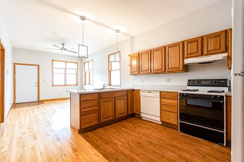 A kitchen with wooden cabinets and a white dishwasher.