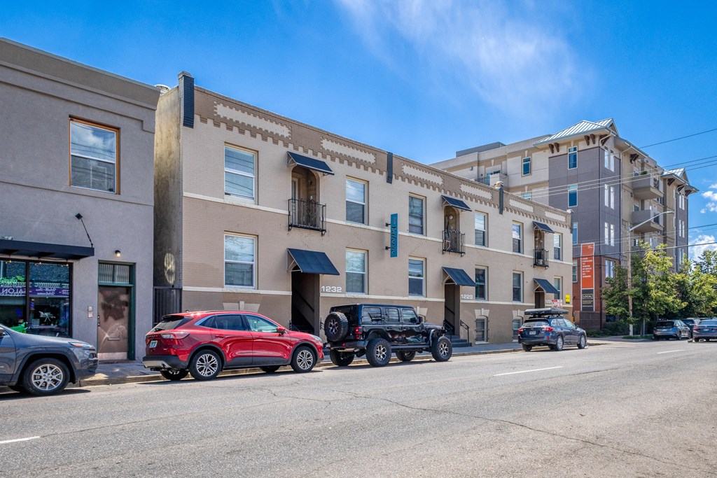 a city street with cars parked in front of a building