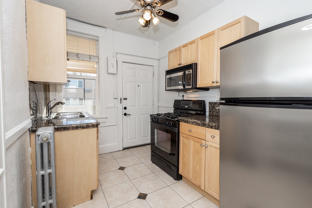 a kitchen with black appliances and wooden cabinets