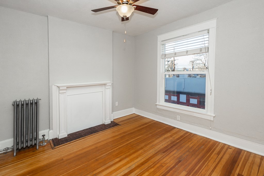 the living room of a house with wood floors and a ceiling fan