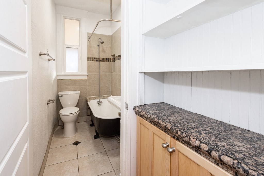 a bathroom with a toilet and a tub and a sink