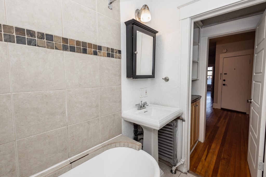 a bathroom with a sink and a tub and a mirror