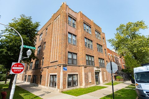 A red brick building with a blue sign on the bottom right.