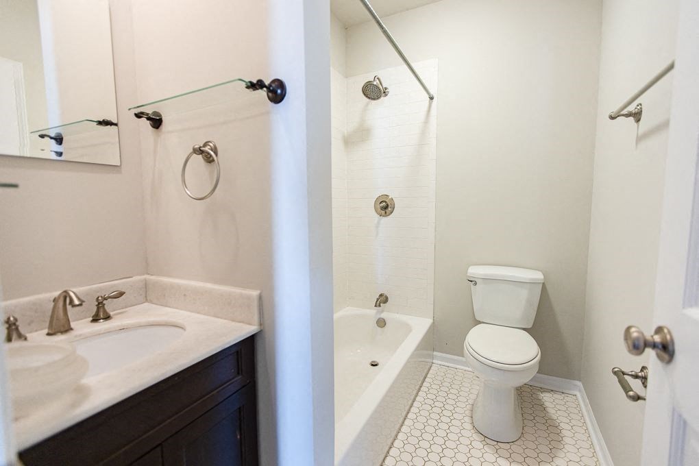 a bathroom with a toilet and a tub and a sink