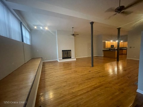 A living room with wood floors and a fireplace.