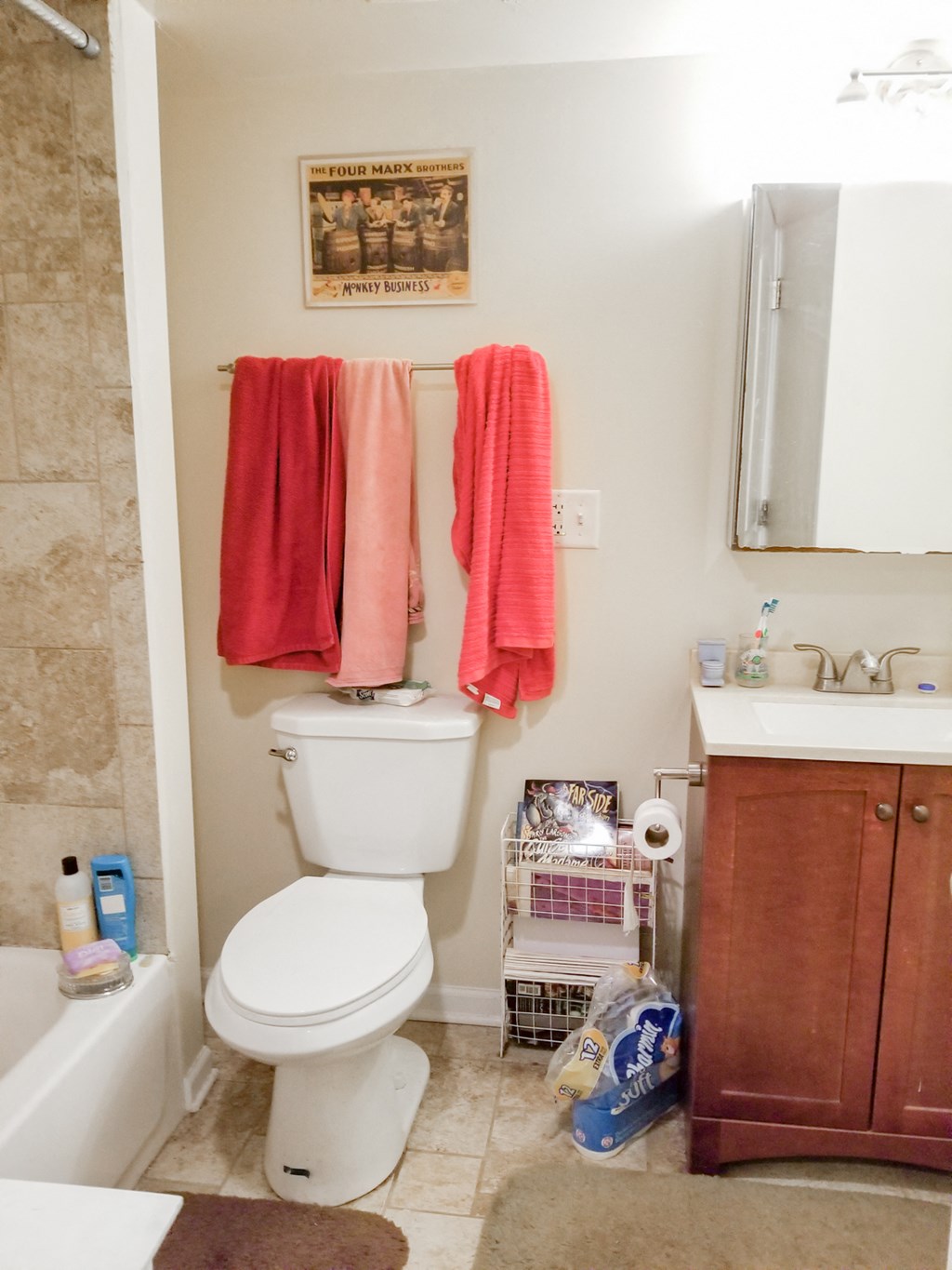 a bathroom with a toilet and two orange towels