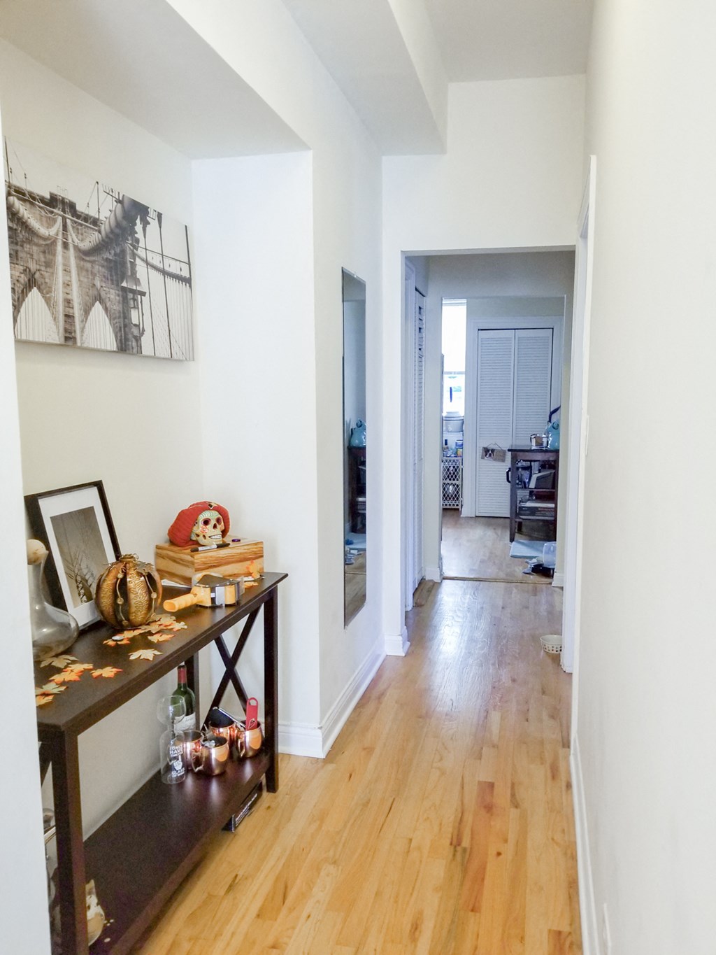 a hallway with a wooden floor and white walls and a long hallway with white walls