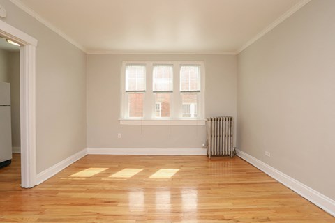 a living room with wood floors and a radiator and a window