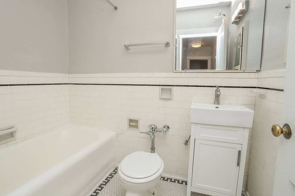 a white bathroom with a sink toilet and bath tub