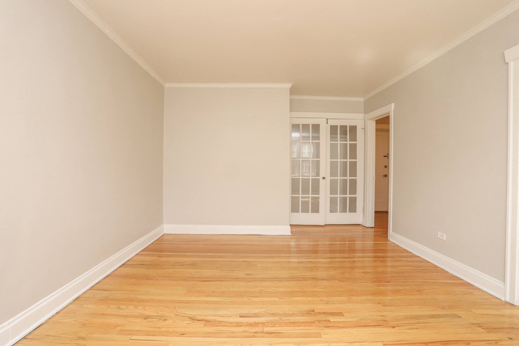 an empty living room with wood floors and white walls