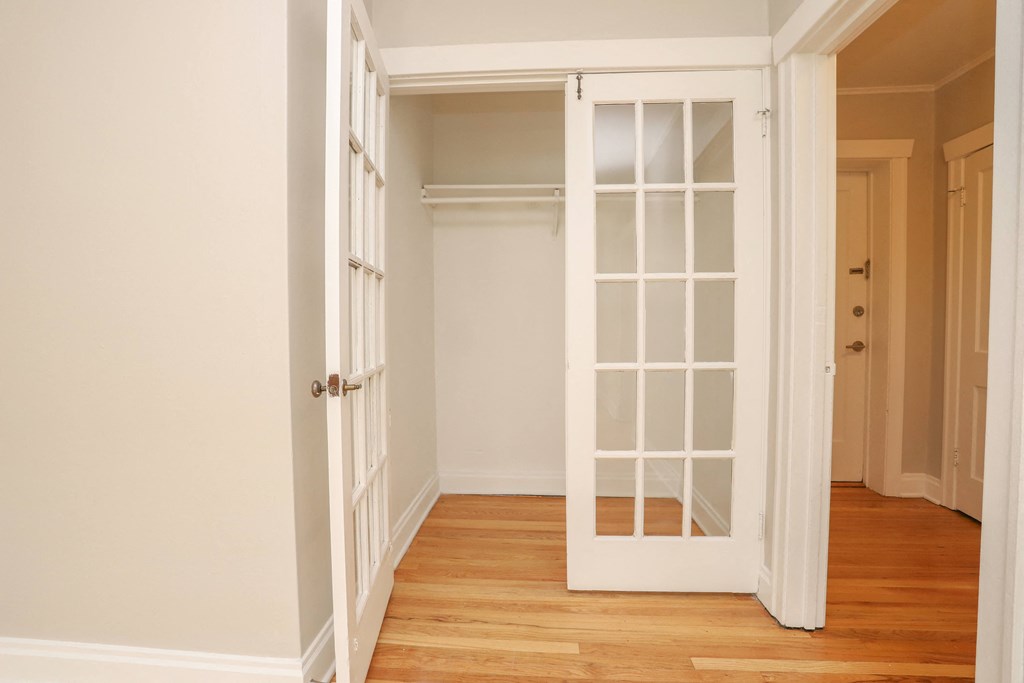 a hallway with a white door open to a closet