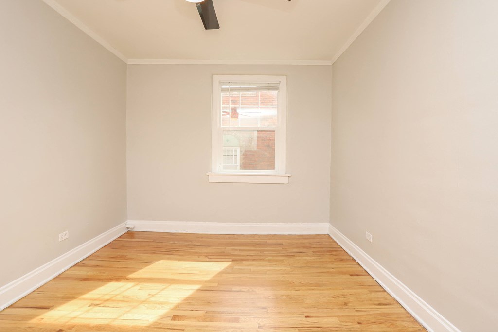 an empty room with wooden floors and a window