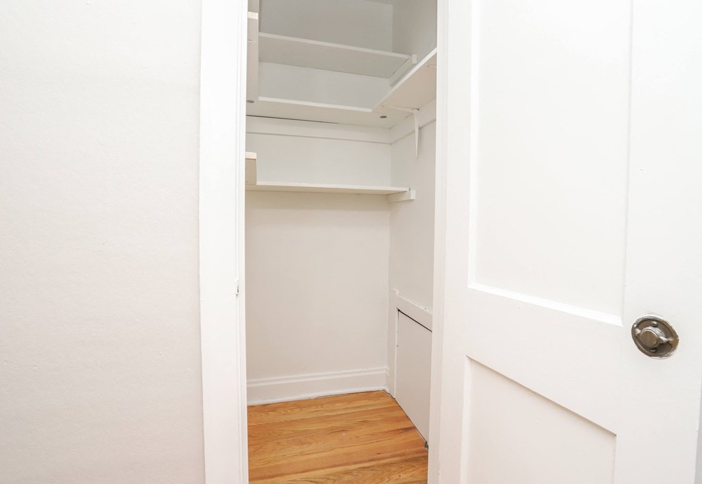 an empty closet in a room with wood floors and white walls