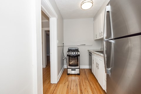 A kitchen with a stove and refrigerator.