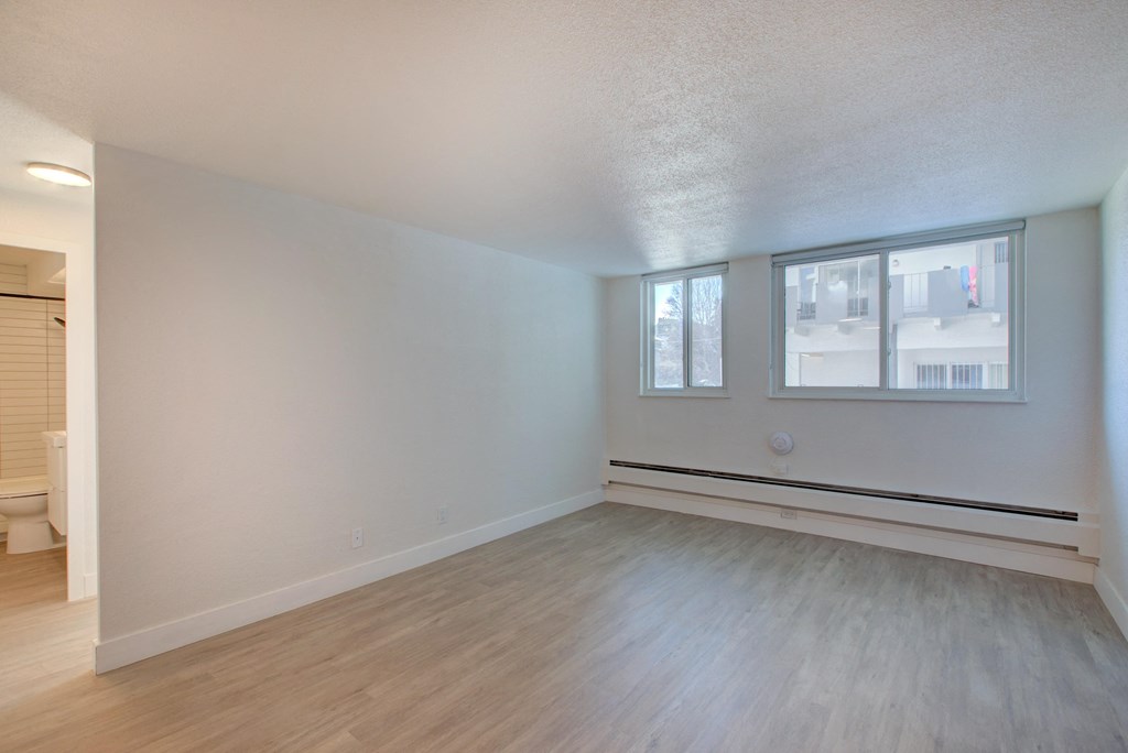 the living room and dining room of an empty apartment