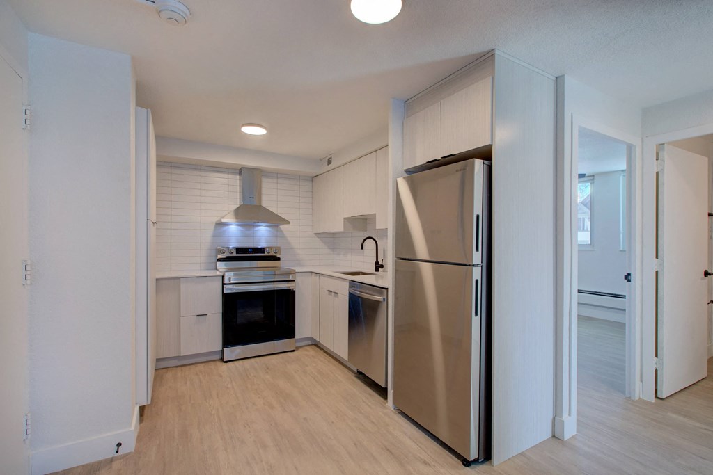 a renovated kitchen with stainless steel appliances and white cabinets