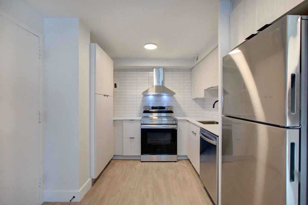 a kitchen with stainless steel appliances and white cabinets