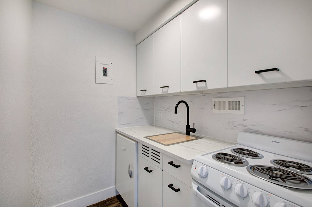 a kitchen with white cabinets and white appliances and a white stove top oven