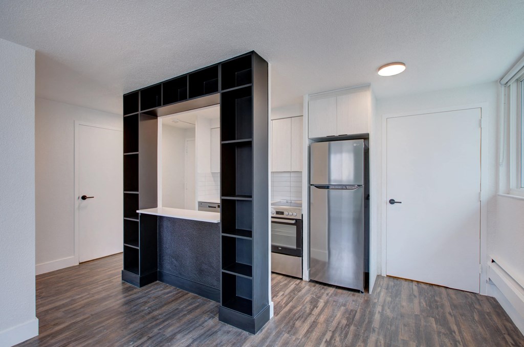a small kitchen with a refrigerator and a mirror