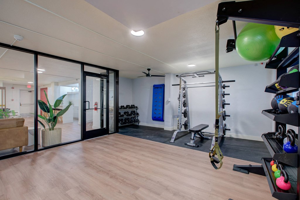 a home gym with glass doors and a wood floor