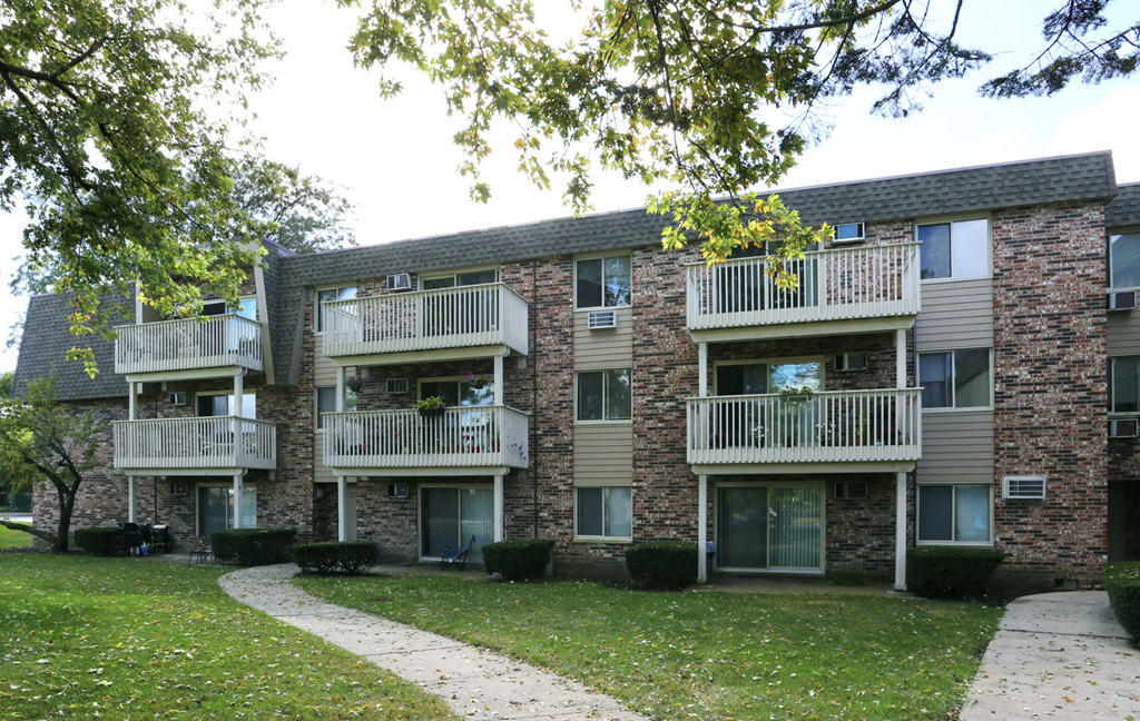 an apartment building with balconies and a sidewalk