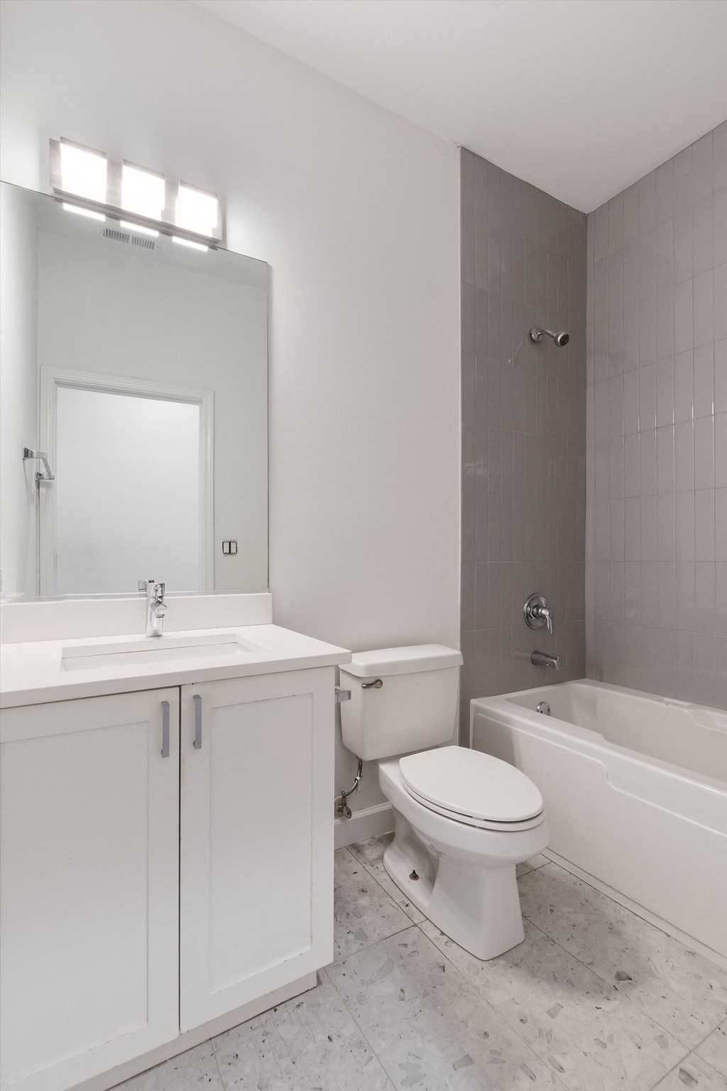 a bathroom with white cabinets and a white toilet