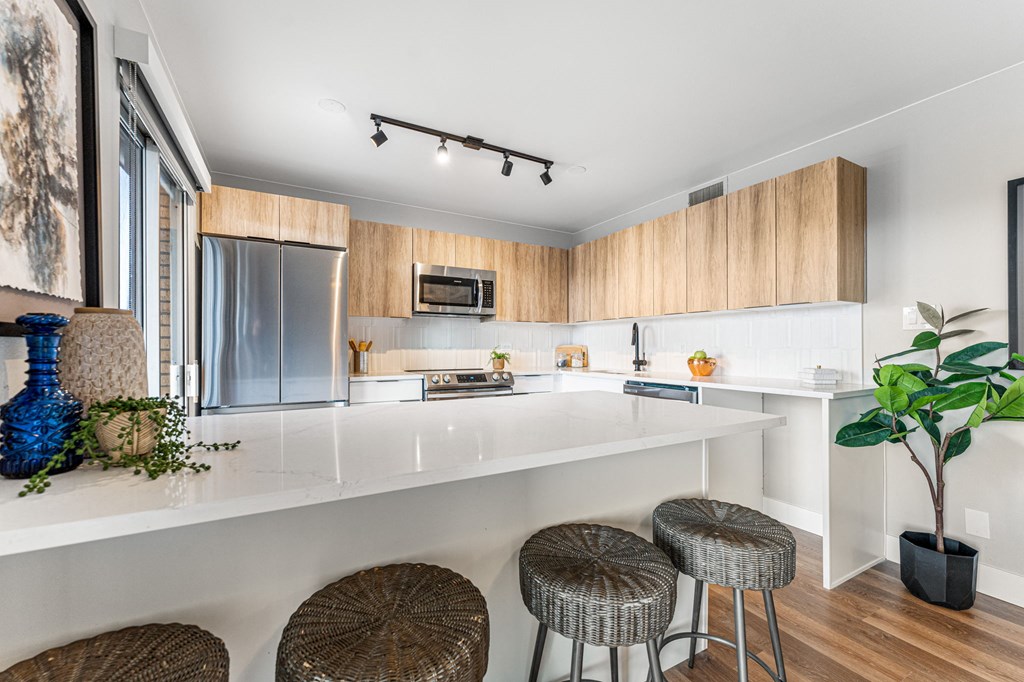 a kitchen with a long peninsula island and three stools