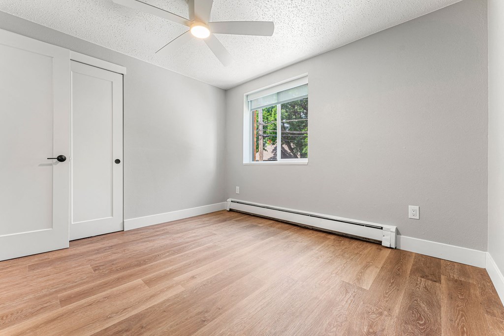 a bedroom with hardwood floors and a ceiling fan