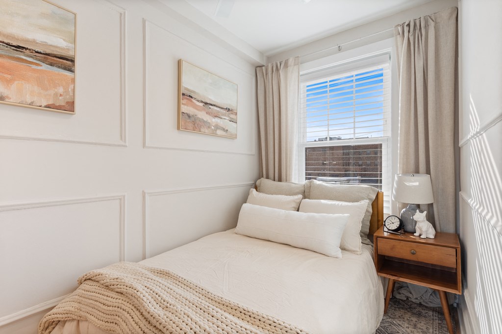 a small bedroom with a bed and a window