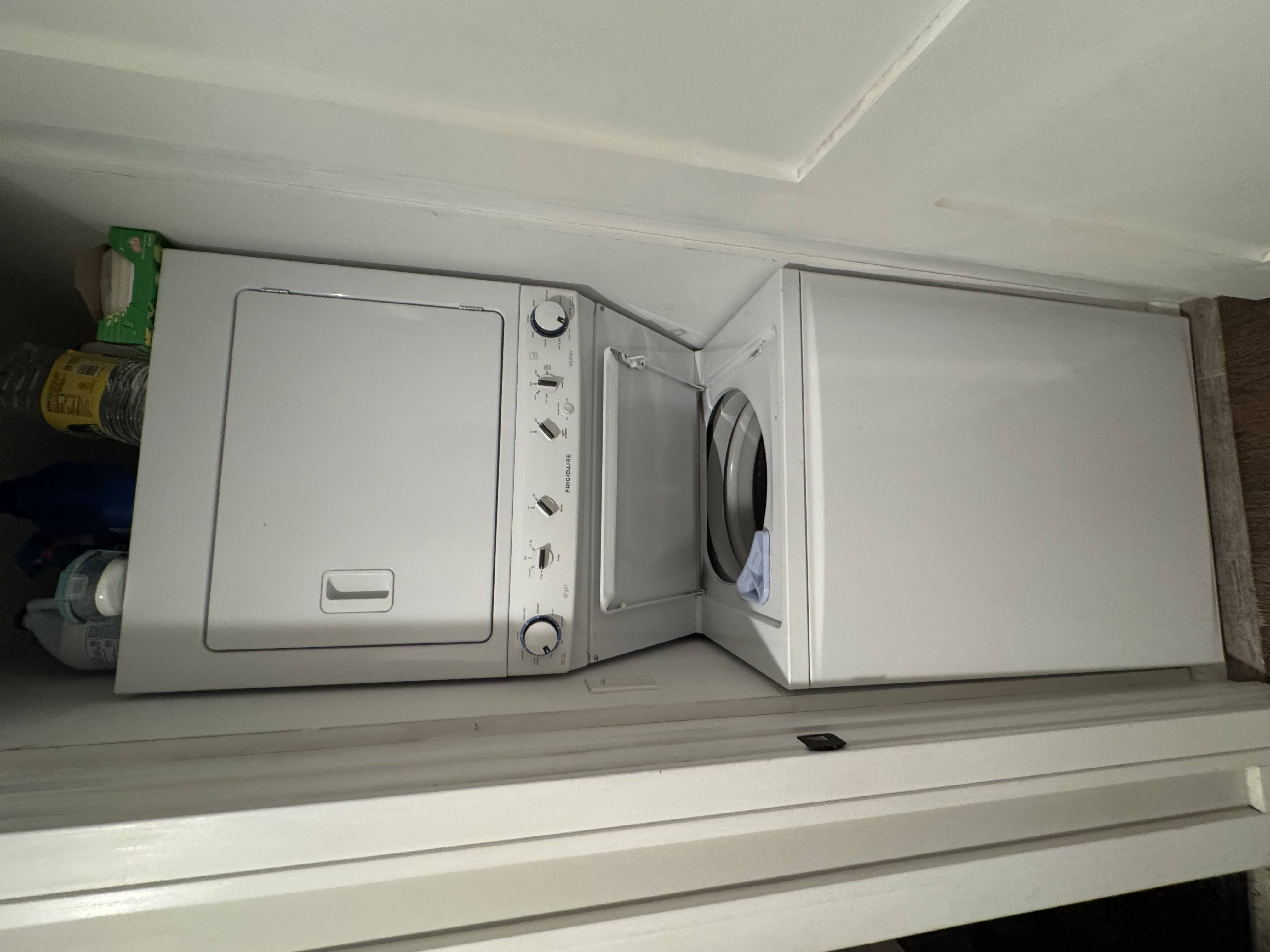 A white dishwasher and dryer are sitting on a shelf.
