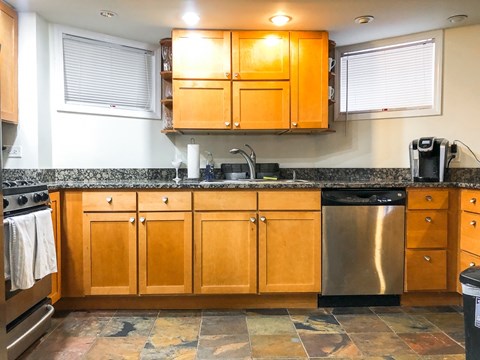 A kitchen with wooden cabinets and a tiled floor.