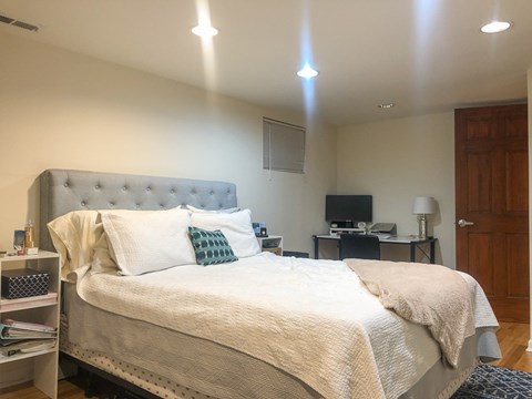 A bedroom with a large bed and a television in the corner.