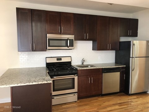 a kitchen with wooden cabinets and stainless steel appliances and granite counter tops