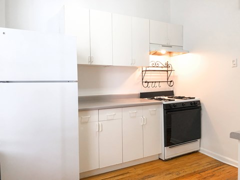 A kitchen with white cabinets and a black stove top oven.