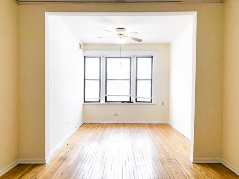 A room with a window and a ceiling fan.