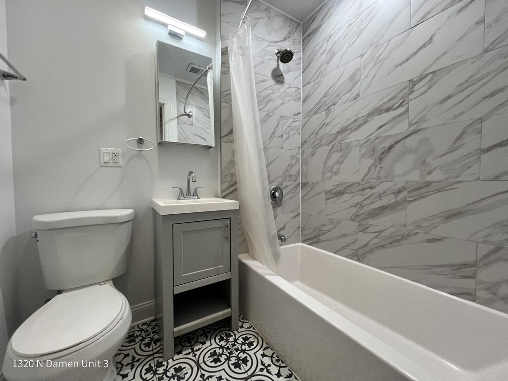 a bathroom with a toilet and a tub and a sink