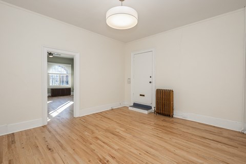 A room with a wooden floor and a radiator.