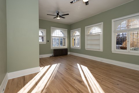 A room with wooden floors and a ceiling fan.