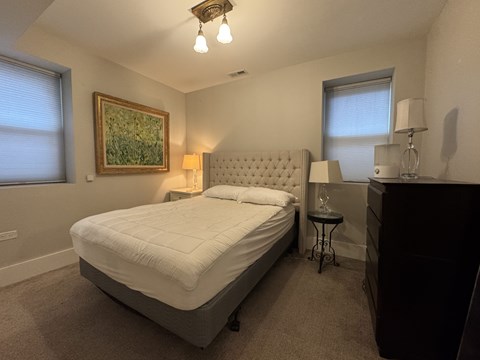 A bedroom with a large bed and a painting on the wall.