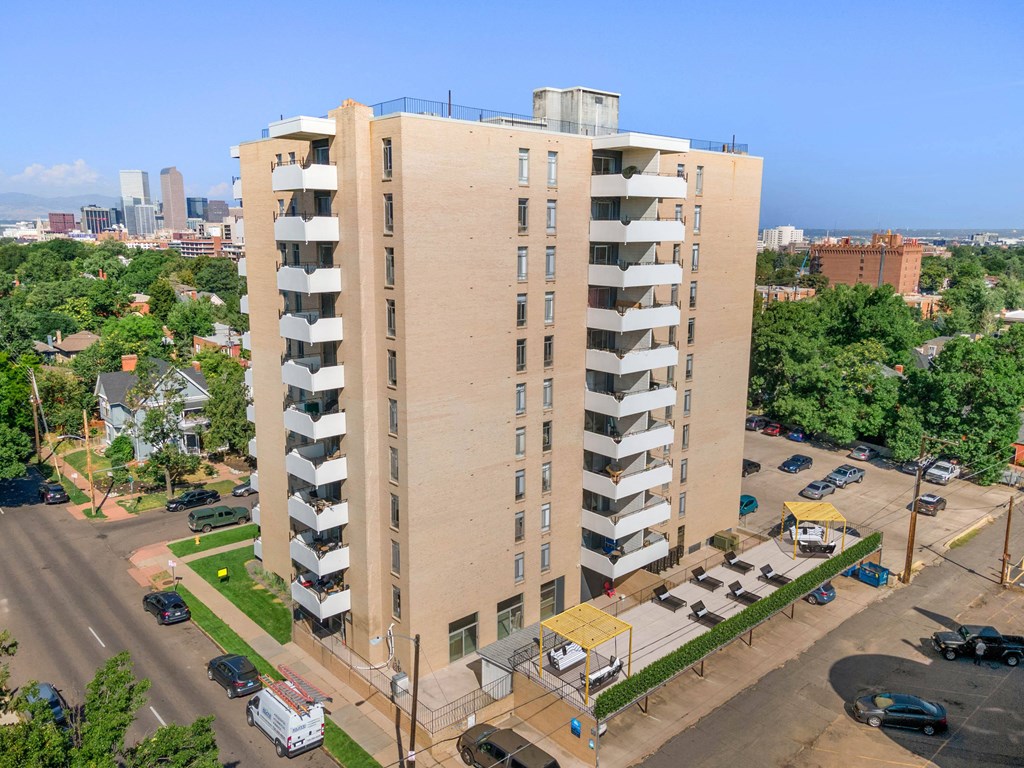 an aerial view of a tall building with a city in the background