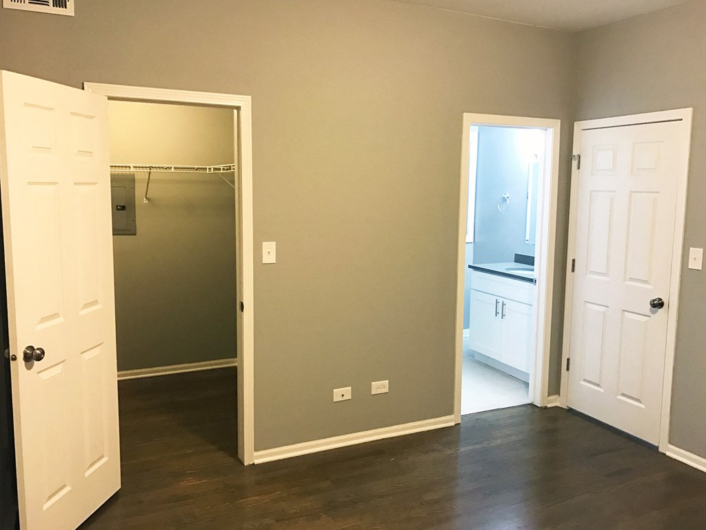 a bedroom with a closet and a door to a bathroom