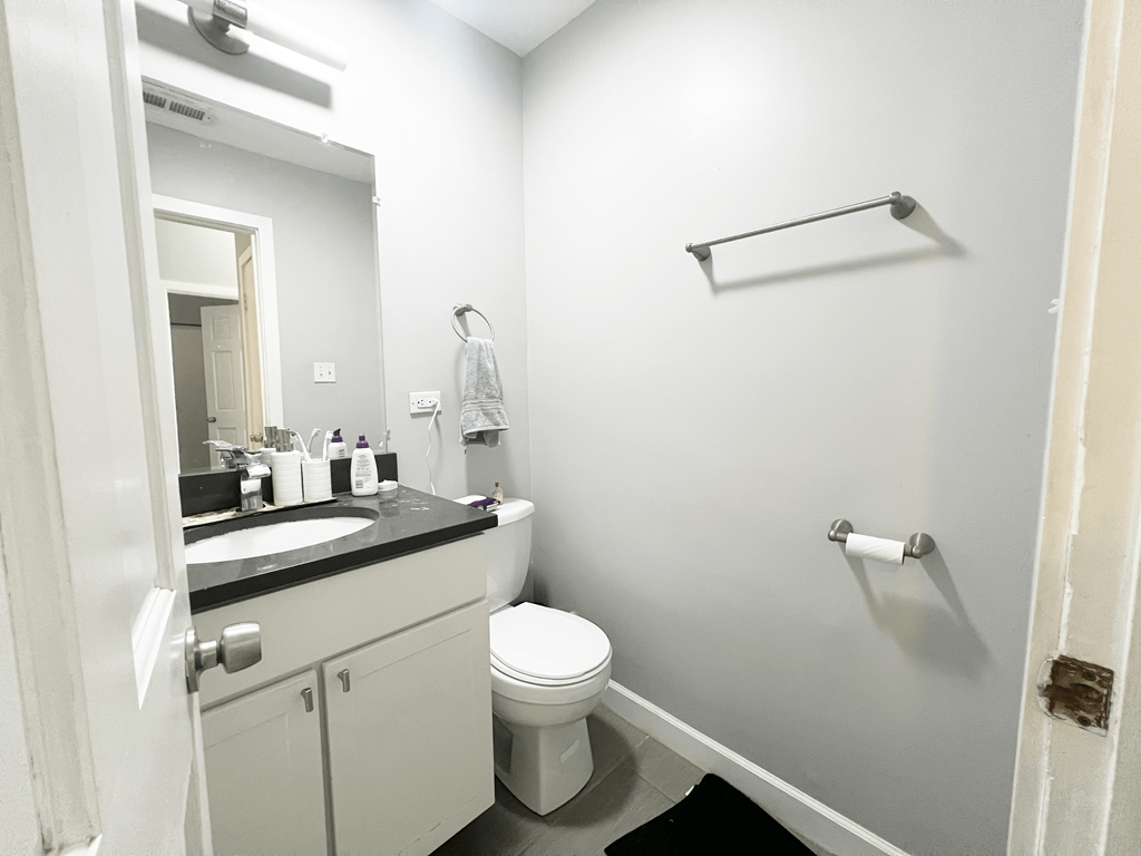 a bathroom with a toilet and a sink and a mirror